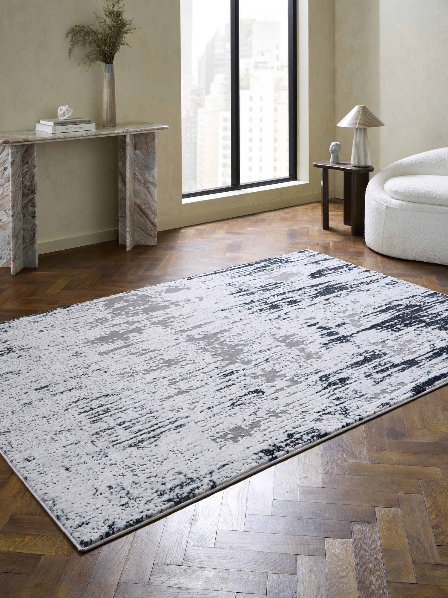 Apollo rectangular rug in grey and navy, beside a console table and a tall window.