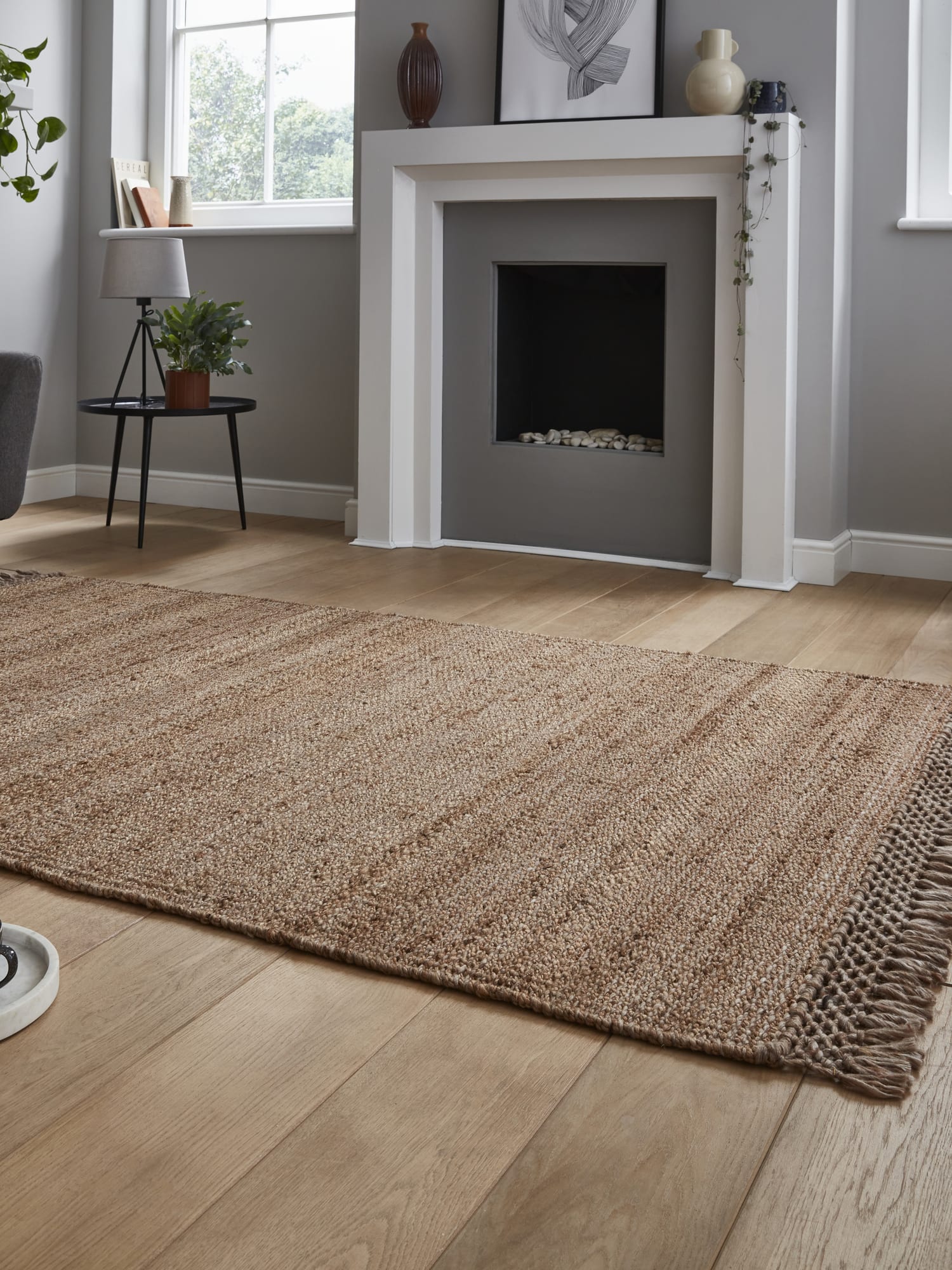 Bazaar Tonal Stripe rectangular rug in natural, at a low angle showing the fringe and woven surface.
