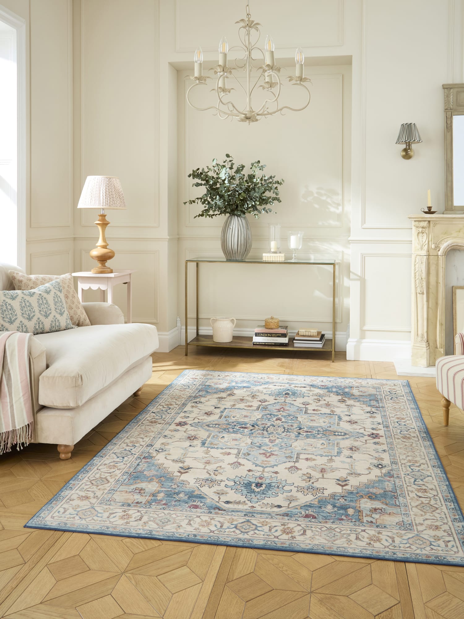 Bohemia rectangular rug in cream and blue, in a pale living room with a fireplace.