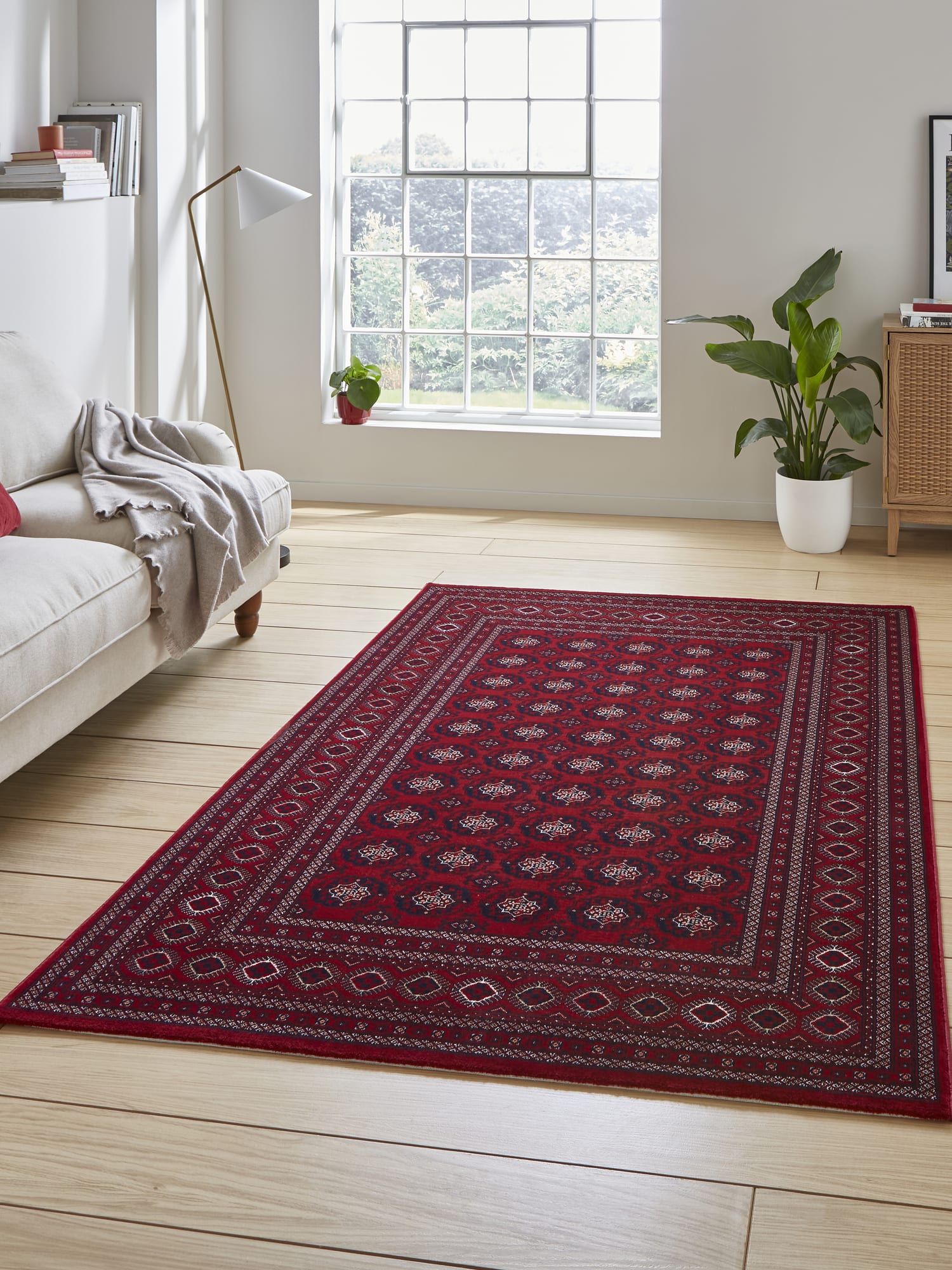 Dubai Diamond Border rectangular rug in red, beside a pale sofa and a large window.