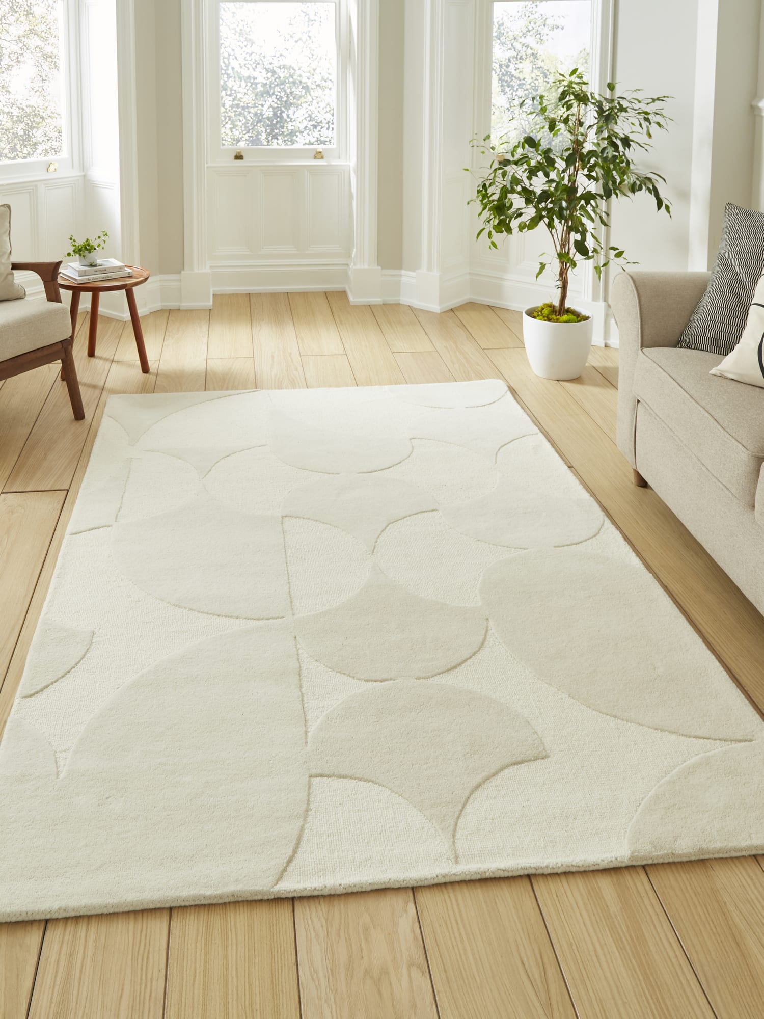 Hudson Bay Interlocking Circles rectangular rug in ivory, beside a pale sofa and tall windows.