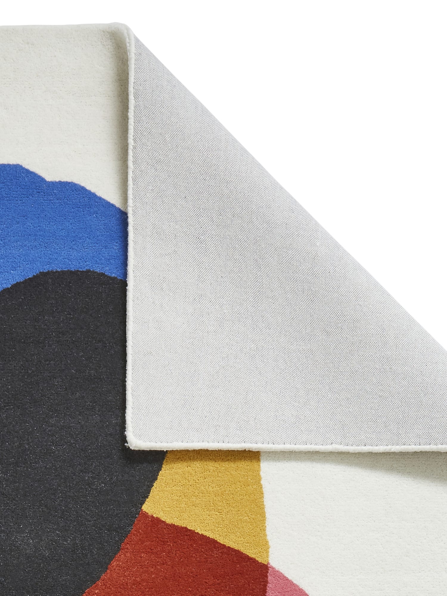 Inaluxe Transmission rectangular rug in cream with blue, pink, yellow, red, teal and dark shapes, with a corner folded back to show the underside.