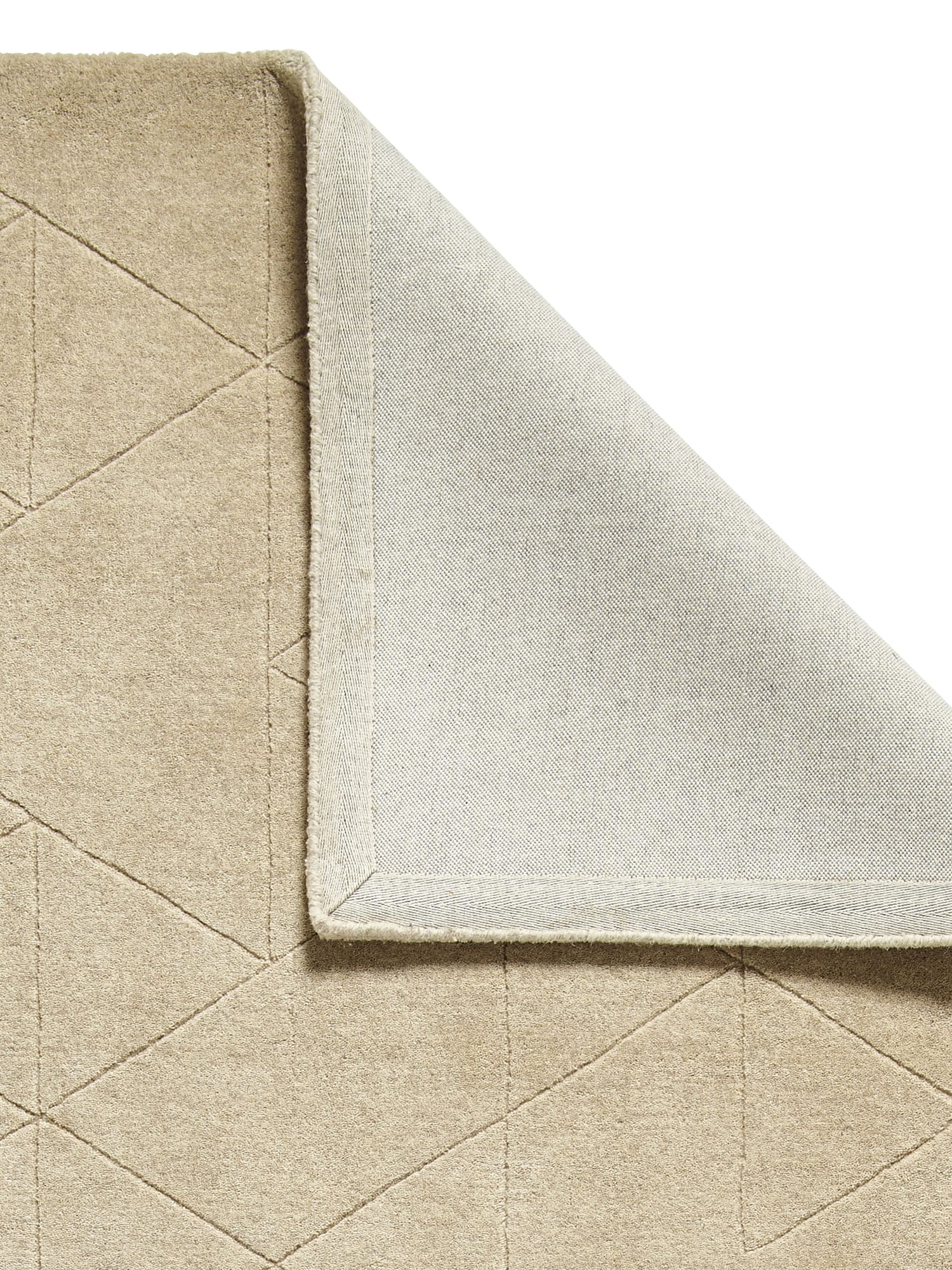 Kasbah rectangular rug in beige, with a corner folded back to show the underside.