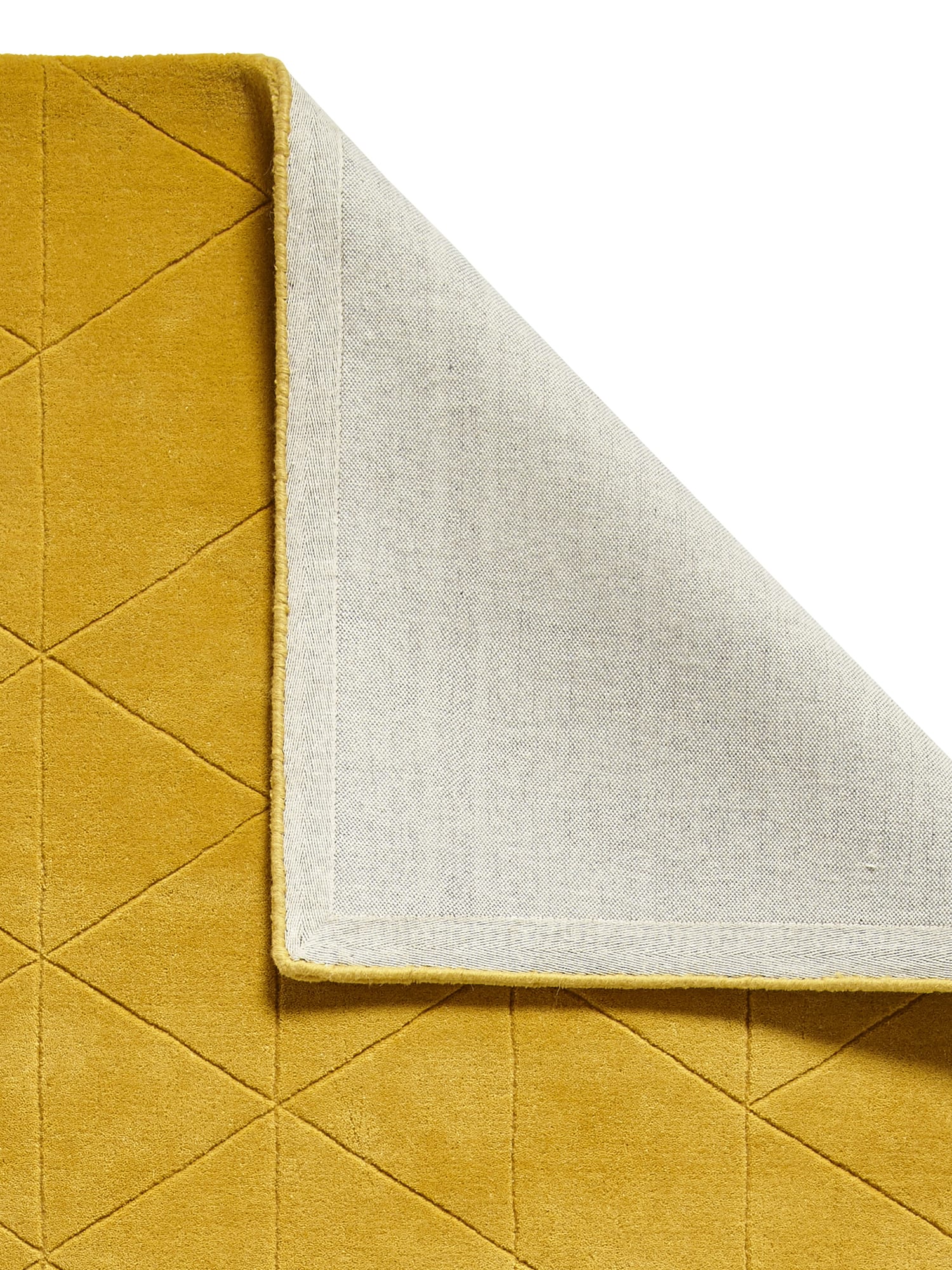 Kasbah rectangular rug in ochre, with a corner folded back to show the underside.