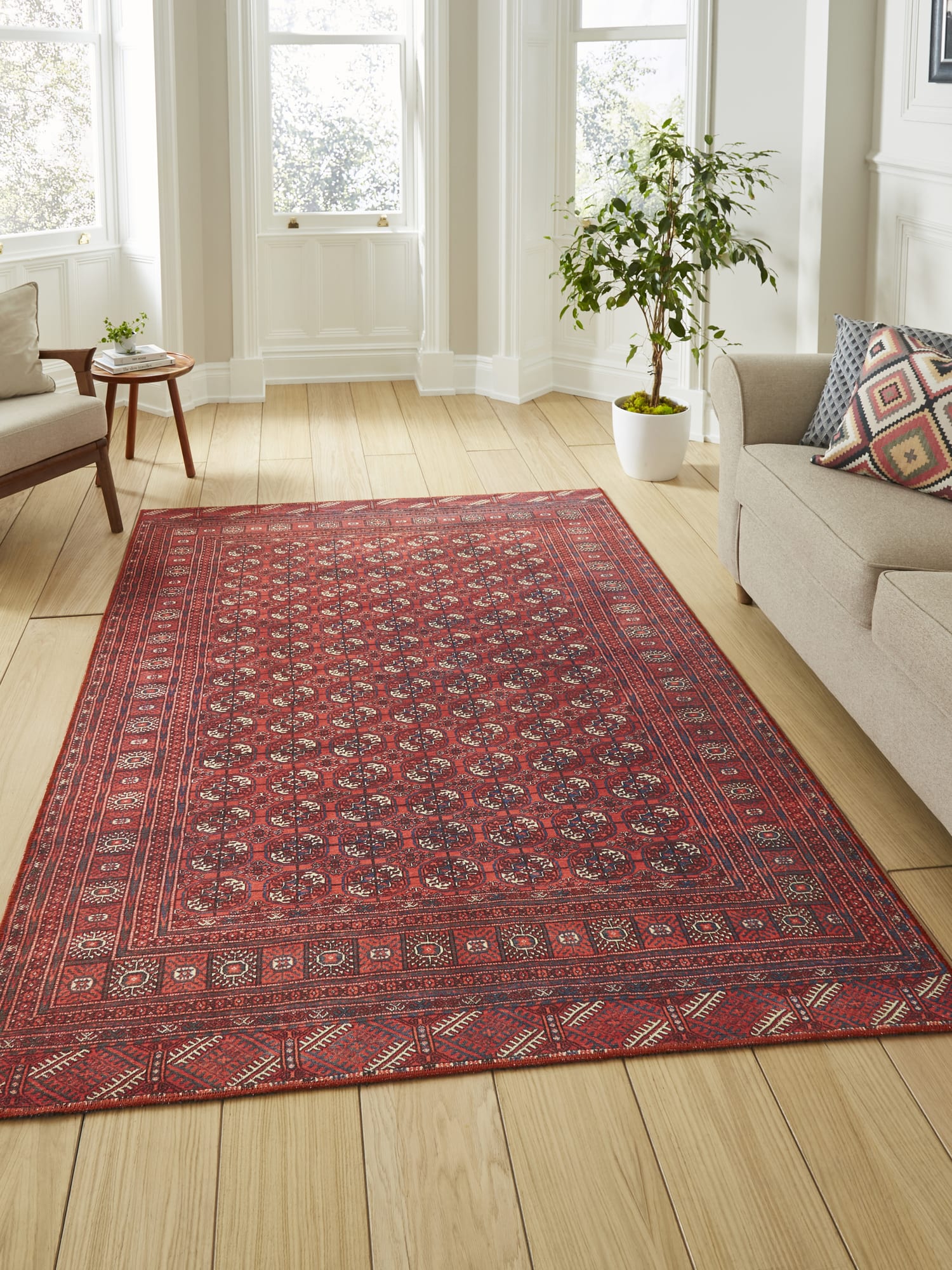 Kashmar Geometric Rows rectangular rug in red, beside a pale sofa and a wooden cabinet.