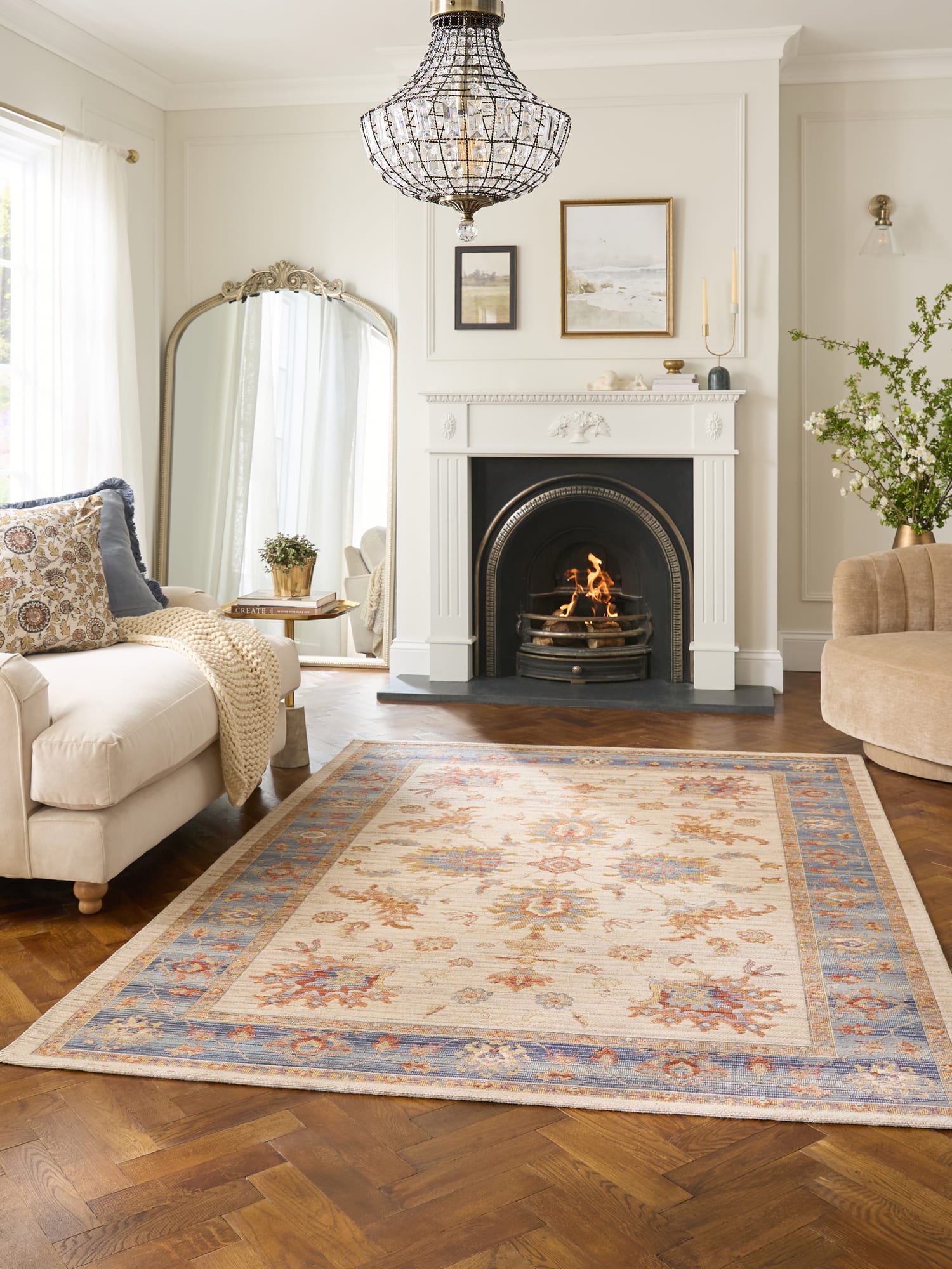 Quartz rectangular rug in ivory and blue, in a room with a fireplace and parquet floor.