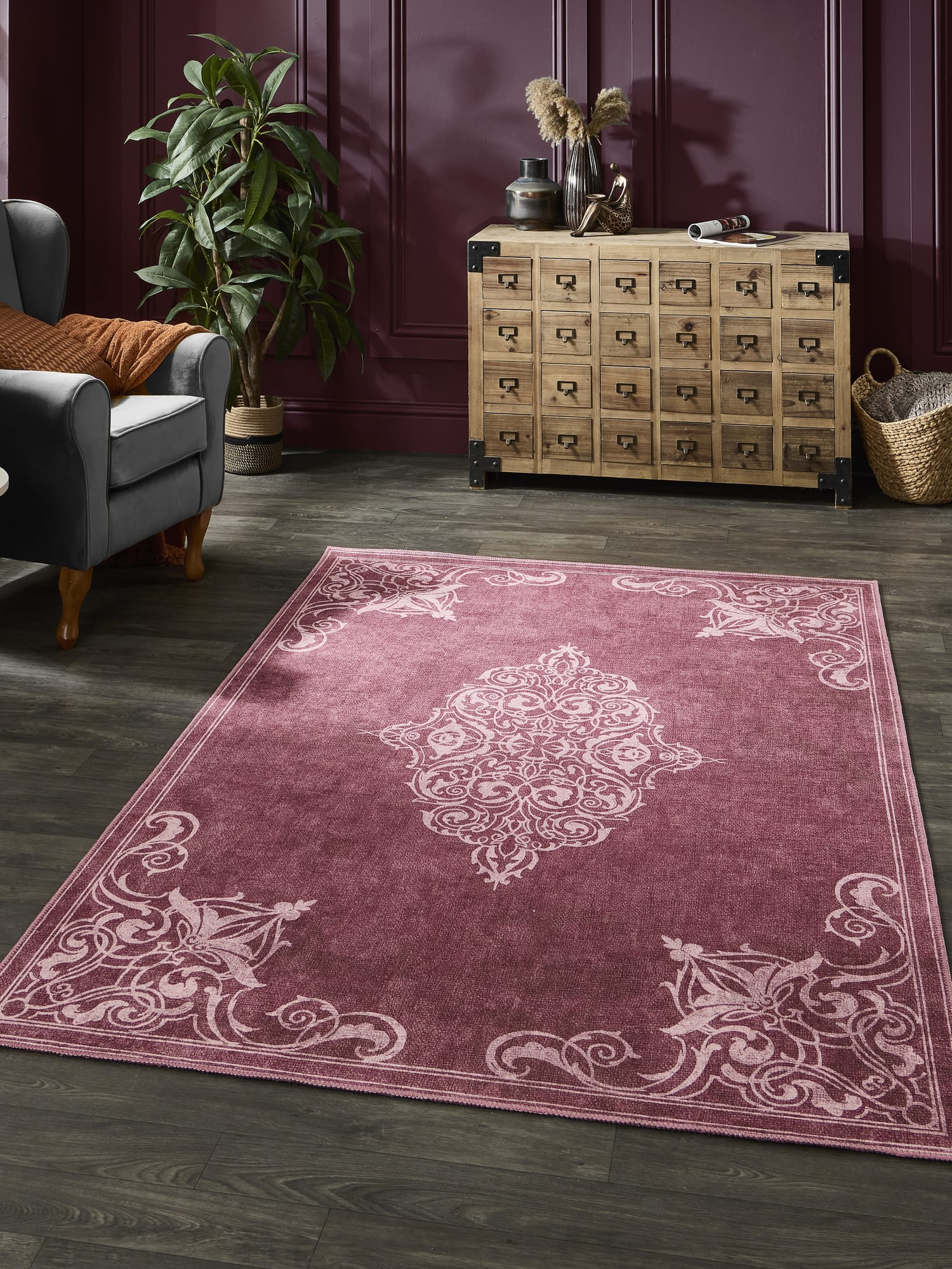 Sarabande rectangular rug in red, beside an armchair and a many-drawer cabinet.