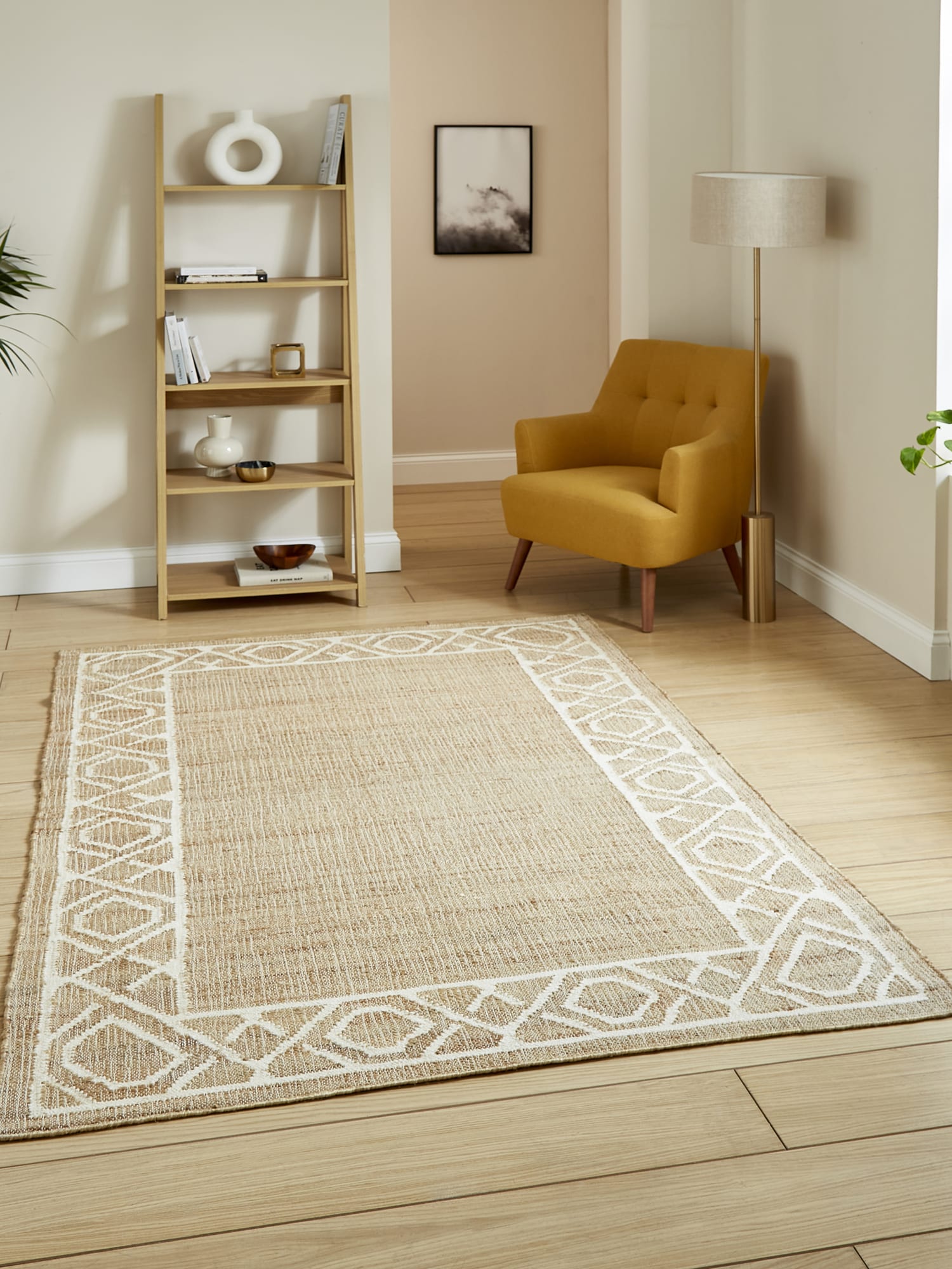 Spartan Diamond Border rectangular rug in natural and ivory, beside a mustard armchair and open shelving.